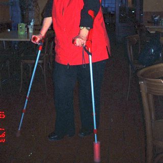 Person in red costume holding glowing poles.