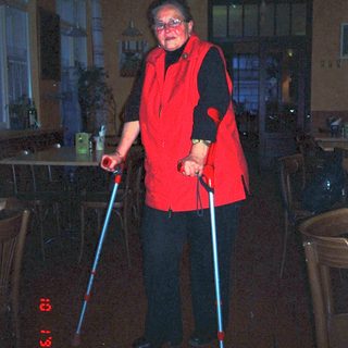 Person in red costume holding glowing poles.