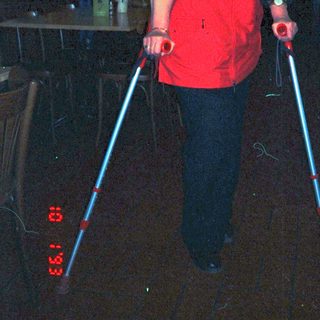 Person using illuminated walking poles indoors.