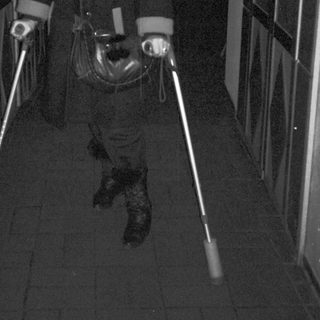Person using illuminated canes in dimly lit elevator.
