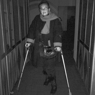 Person using illuminated canes in dimly lit elevator.
