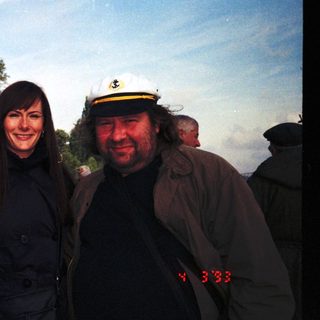 Three people posing together outdoors, smiling.