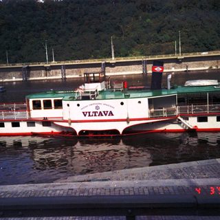 Riverboat named Vltava docked at pier.
