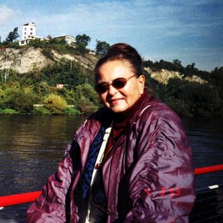 Woman smiling by river on boat.