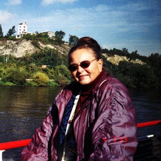 Woman smiling by river on boat.