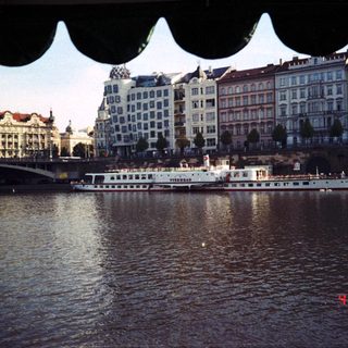 Historic European cityscape by river with boats.