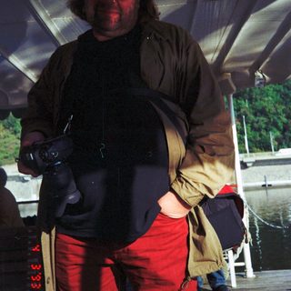 Person in outdoor gear standing on boat.