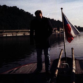 Man standing on boat near water with Czech flag.