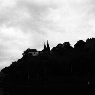Silhouetted hilltop church with twin spires.