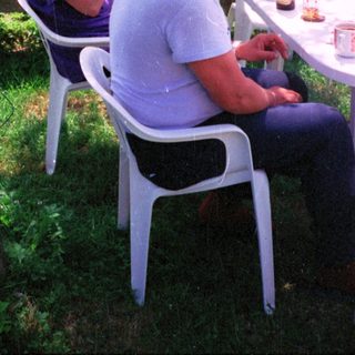 Two women outdoors with a small white dog.