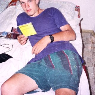 Young man holding game card on bed.