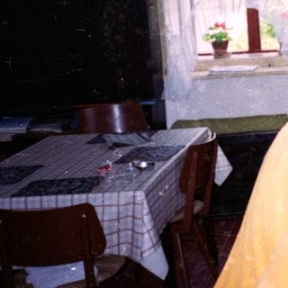 Two women in a kitchen during snowfall.