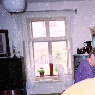 Two women in a kitchen during snowfall.