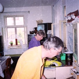 Two women in a kitchen during snowfall.