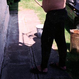 Man using a long pole to clean gutter.