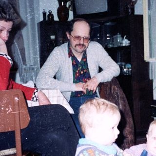Family gathering indoors with adults and young children.