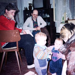 Family gathering indoors with adults and young children.
