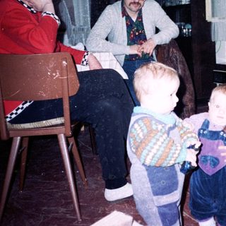 Family gathering indoors with adults and young children.