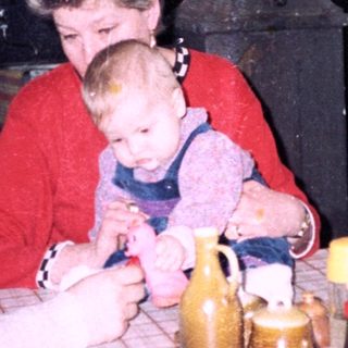Family gathering around a table in a cozy kitchen.