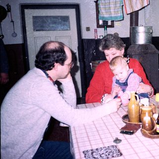 Family gathering around a table in a cozy kitchen.