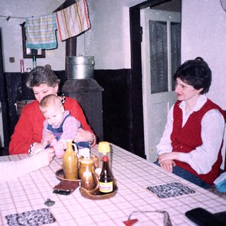 Family gathering around a table in a cozy kitchen.