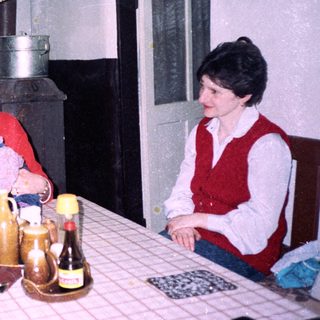 Family gathering around a table in a cozy kitchen.