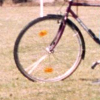 Person in cycling gear poses with bike near medieval ruins.