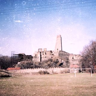 Ruins of an old stone castle in a grassy area.