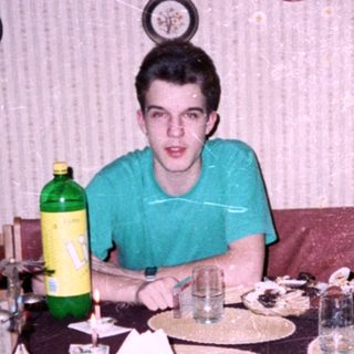 A person sitting at a home dining table with food.