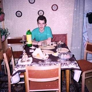 A person sitting at a home dining table with food.