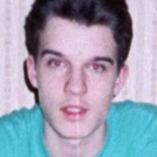 Young man sitting at a vintage dining table.