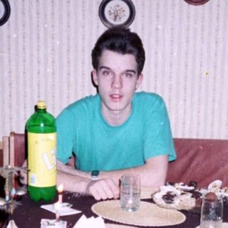 Young man sitting at a vintage dining table.