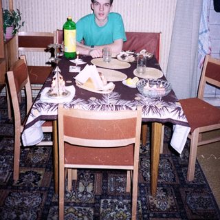 Young man sitting at a vintage dining table.