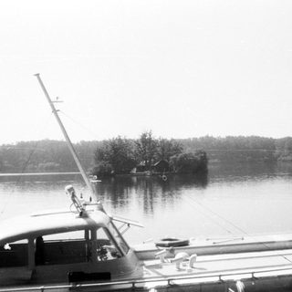 Boat docked near small island in calm water.
