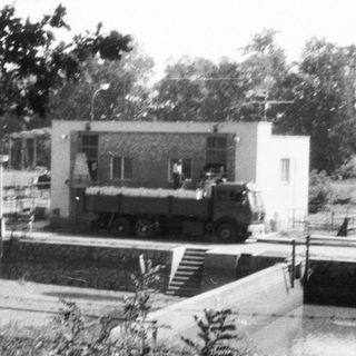 Military truck parked near building in outdoor area.