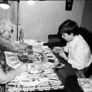 Two women and a boy crafting with paper cutouts.