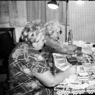 Two women and a boy crafting with paper cutouts.