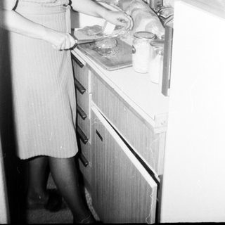 Woman preparing food in vintage kitchen.