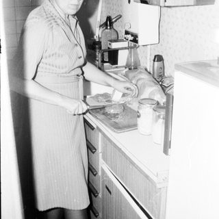 Woman preparing food in vintage kitchen.
