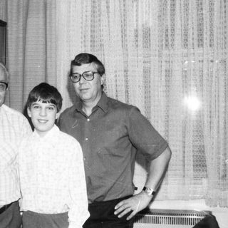 Three-generation family portrait indoors, 1980s style.