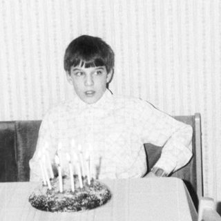 Child sitting at table with birthday candles.
