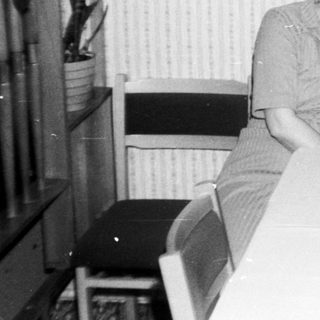Two people posing together indoors at a table.