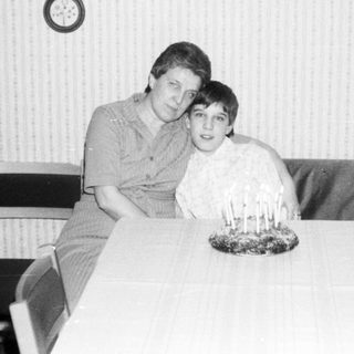 Two people posing together indoors at a table.