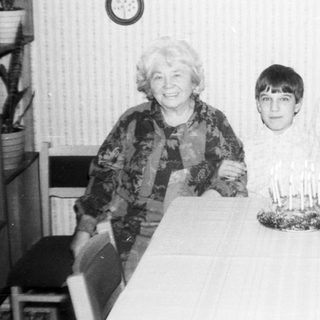 Family celebrating a birthday with candles on cake.