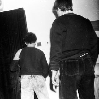 Three people standing near a closed curtained-off area.