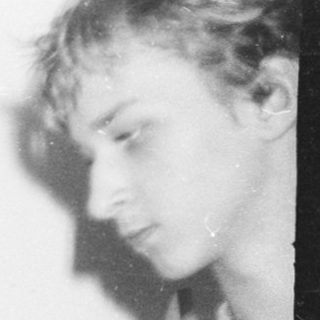 Blurred black-and-white photo of two people indoors.