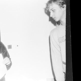 Blurred black-and-white photo of two people indoors.