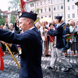 Military veterans parade with flags in public.