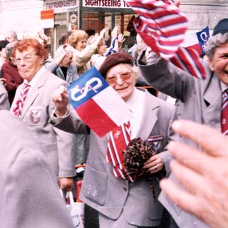 Veterans parade with flags and badges.