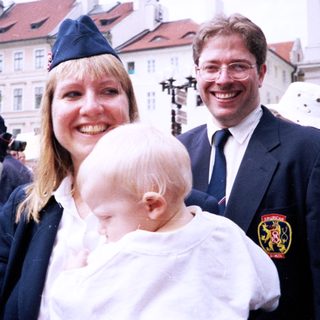 Family posing at outdoor public event.